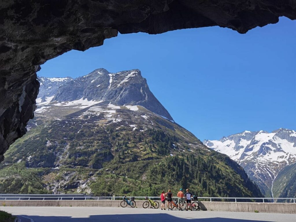 Der Blick am Ende des Tunnels auf die Zillertaler Alpen - die Radfahrer stehen auf der Zillergründl Staumauer