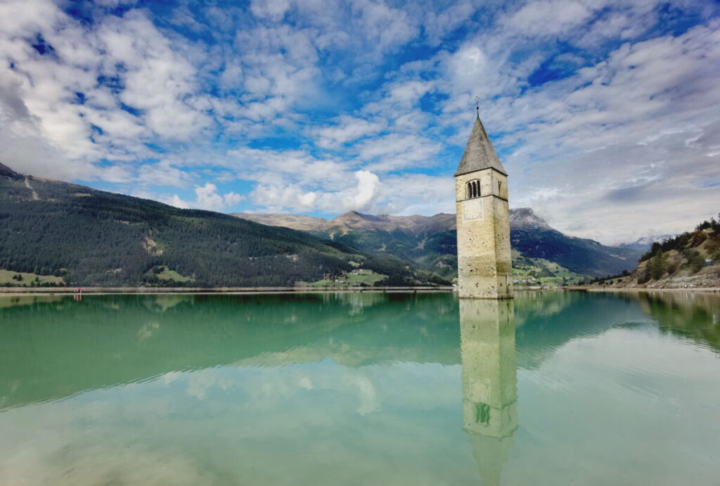 Die schönsten Alpen Seen entdecken - der Reschensee mit dem Kirchturm im See ist sicher der Außergewöhnlichste.